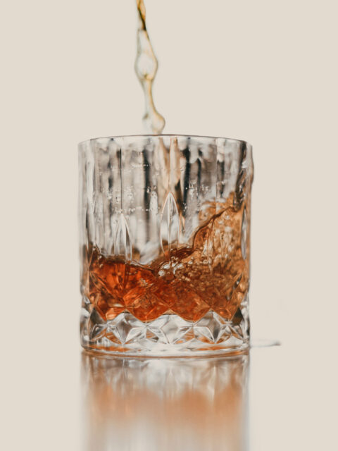 poruing zacerac cocktail in glass